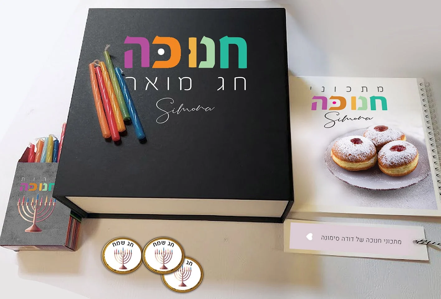 מארזים לחנוכה מארז חנוכה אישי כולל קופסת נרות, מטבעות שוקולד ומחברת מתכוני חנוכה עם שם והקדשה